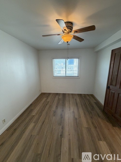 A room with wooden flooring and a ceiling fan.