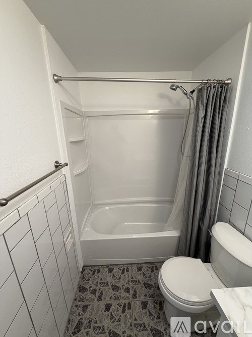A white bathroom with a toilet, tub, and shower.