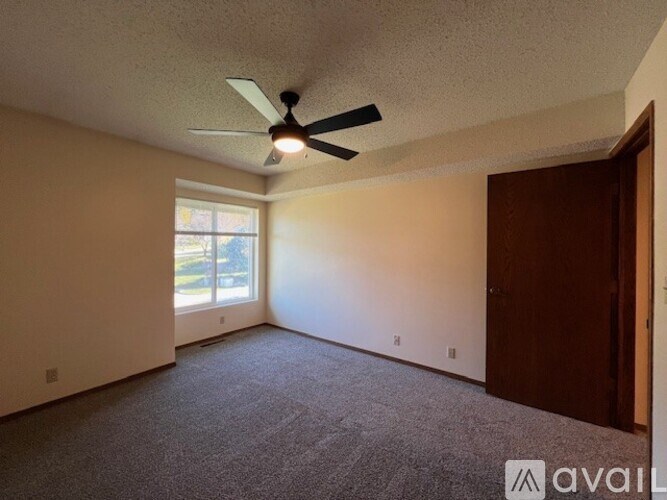 A room with a ceiling fan and a window.
