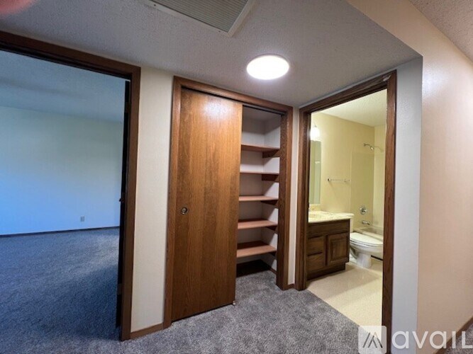 A room with a wooden door and a carpeted floor.