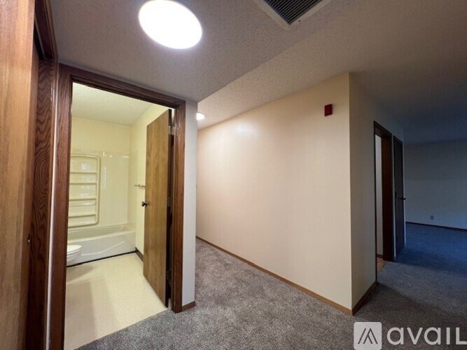A room with a carpeted floor and a doorway leading to another room.