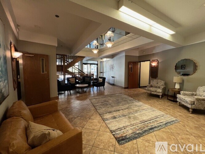 A spacious living room with a large rug and a sofa.