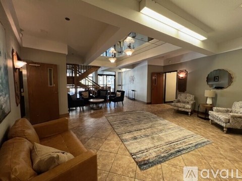 A spacious living room with a large rug and a sofa.