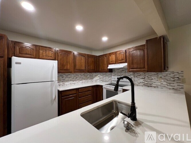 A kitchen with a white fridge and a sink.
