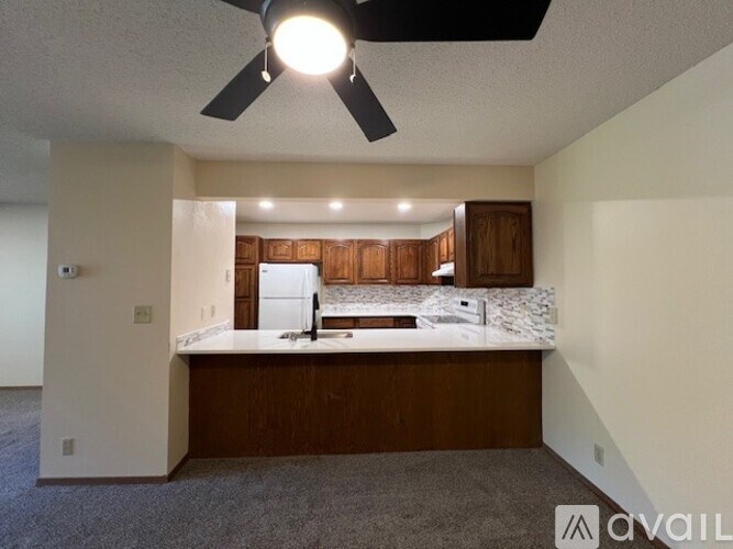 A kitchen with a white countertop and a ceiling fan.