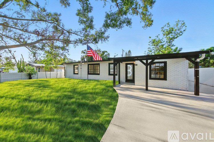 A house with a flag on the roof and a fence in front.