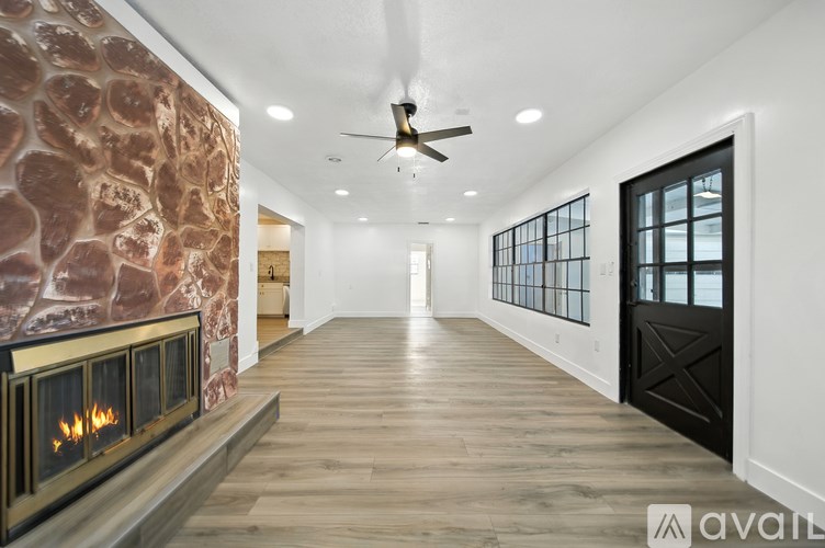 A modern living room with a stone wall and a fireplace.