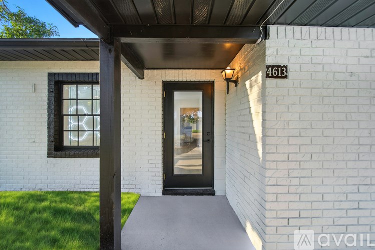 A white house with a black door and a window with a black frame.
