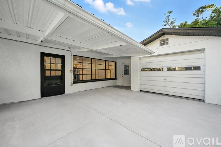 A spacious garage with a white ceiling and black door.