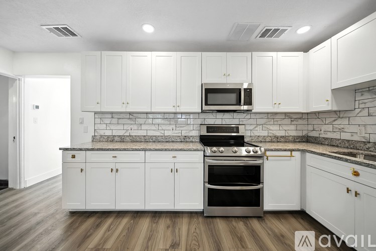A kitchen with white cabinets and a black stove top oven.