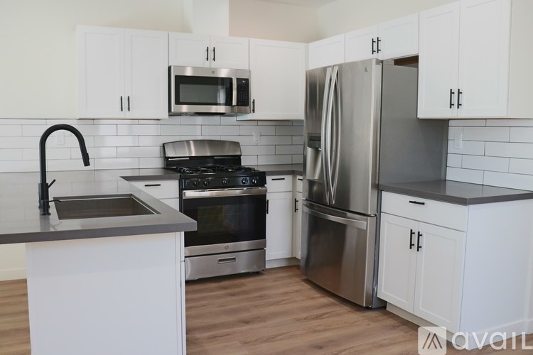A kitchen with white cabinets and stainless steel appliances.