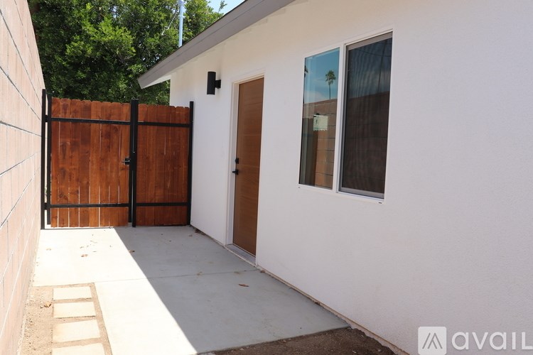 A white house with a brown gate and a brown door.