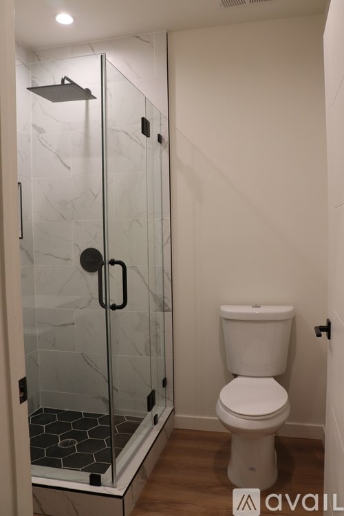 A white toilet in a bathroom with a glass shower door.