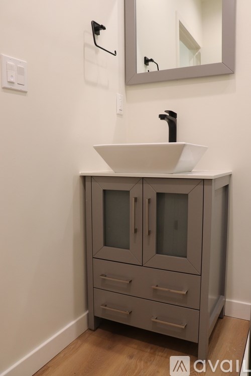 A bathroom vanity with a sink and a mirror above it.