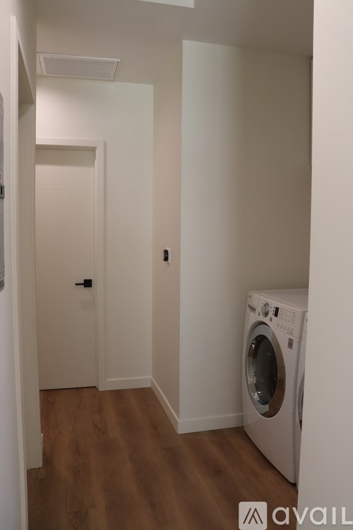 A washing machine is sitting in a small room.