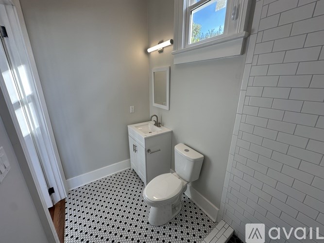 A white toilet in a bathroom with a black and white floor.