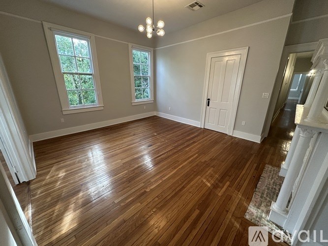 A room with wooden flooring and white walls.