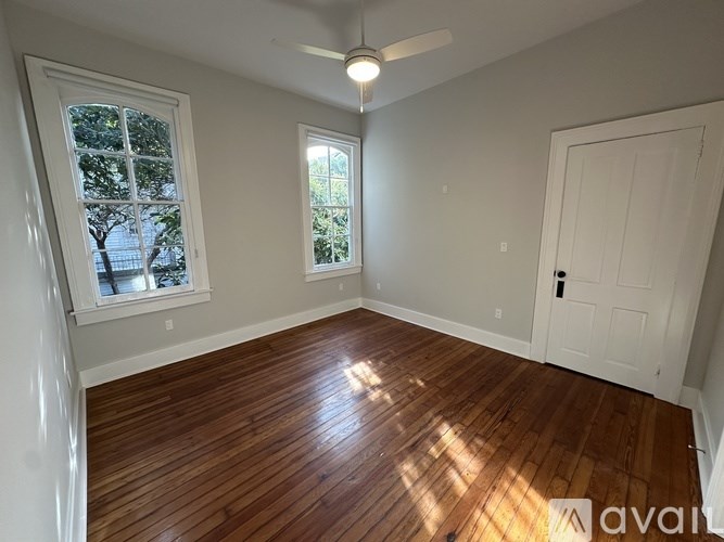 A room with wooden floors and a ceiling fan.
