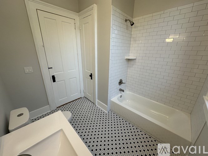 A white bathroom with a toilet, sink, and bathtub.