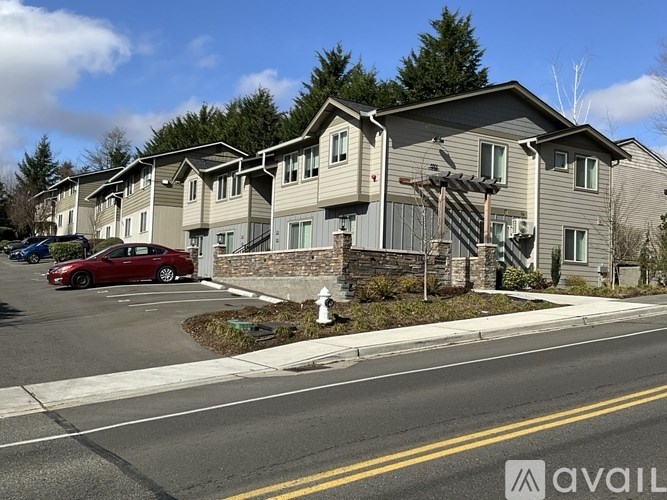 A row of houses with a red car parked in front of the first house.