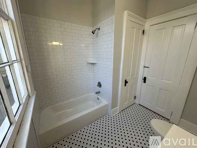 A white bathroom with a black and white floor.