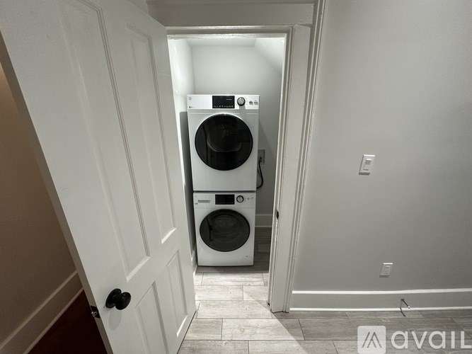 A white washer and dryer in a narrow hallway.