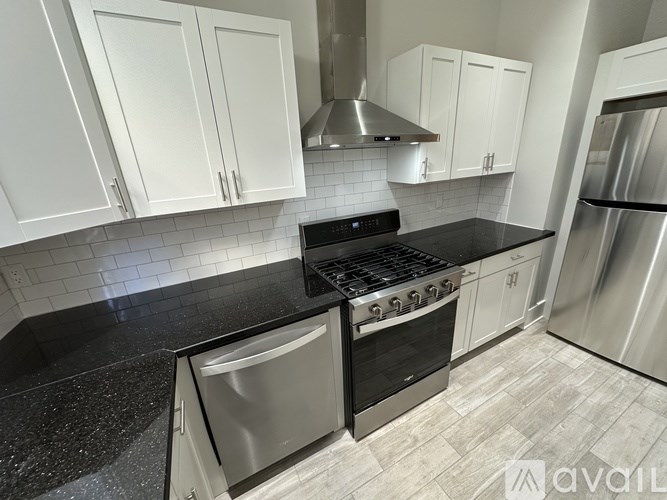 A kitchen with black countertops and white cabinets.