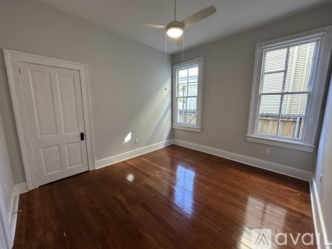 A room with wooden floors and a ceiling fan.