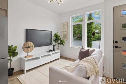 A living room with a white couch and a flat screen TV.
