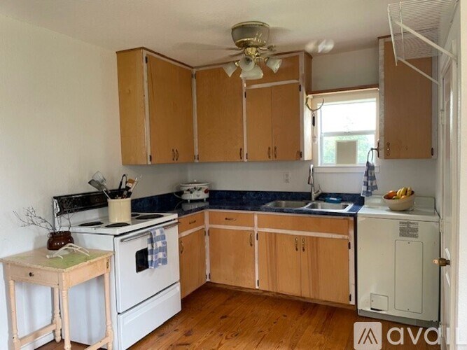 A kitchen with wooden cabinets and a white stove top oven.