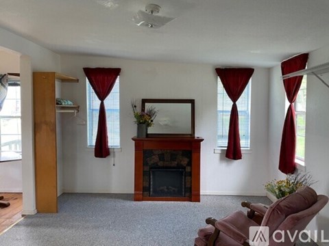 A living room with a fireplace and a painting above it.