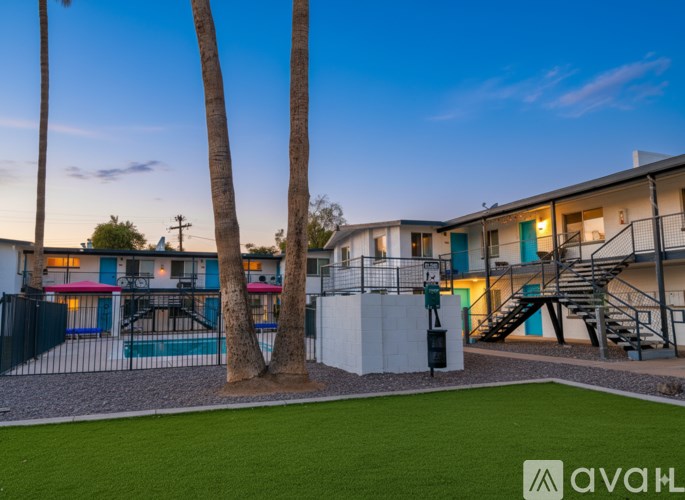 A modern apartment complex with a pool and palm trees.