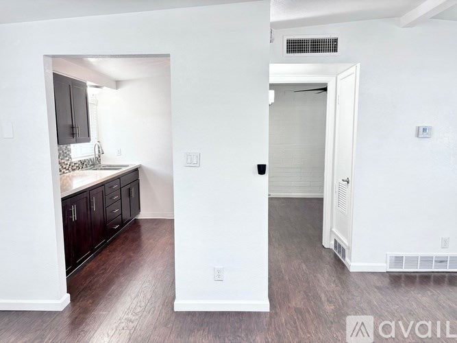 A room with a kitchen area and a hallway.