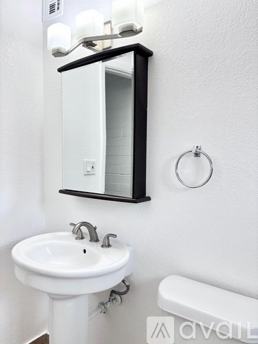 A white sink with a black framed mirror above it.