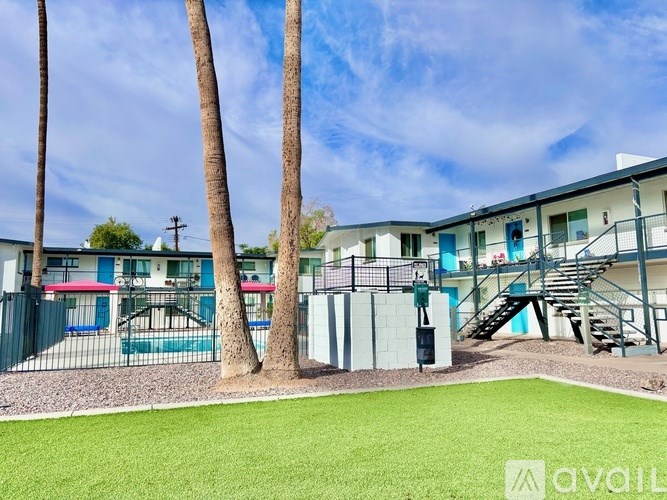 A sunny day at a residential complex with a playground and palm trees.