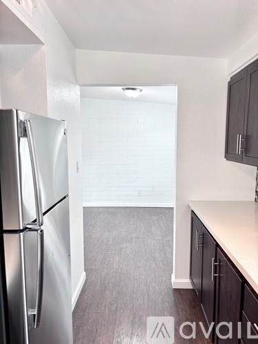 A kitchen with a refrigerator and cabinets.