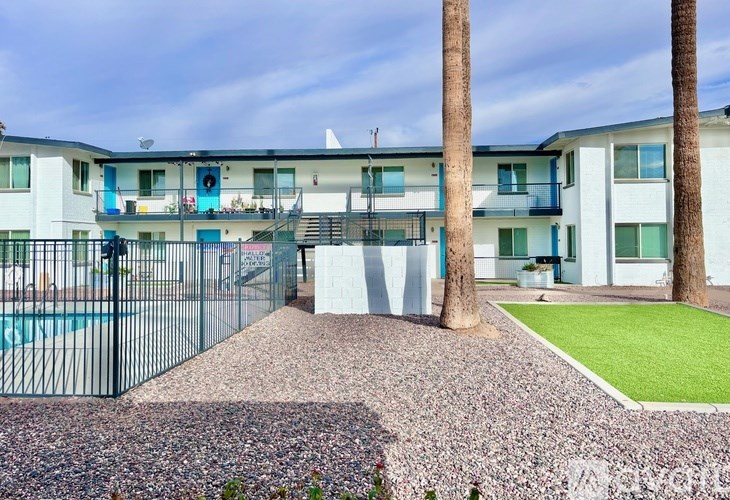 A building with a pool and a fence in front of it.