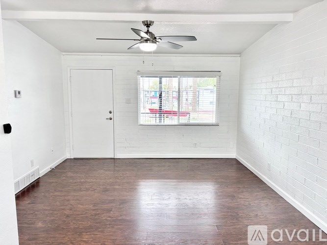 A room with a ceiling fan and a window with blinds.