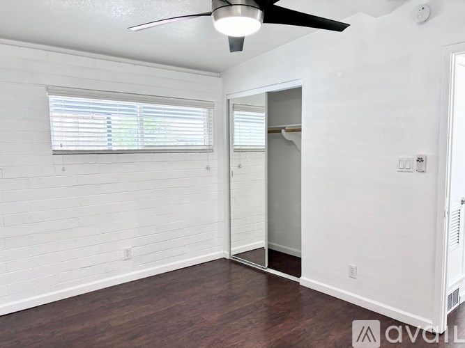A room with a ceiling fan and a window with blinds.