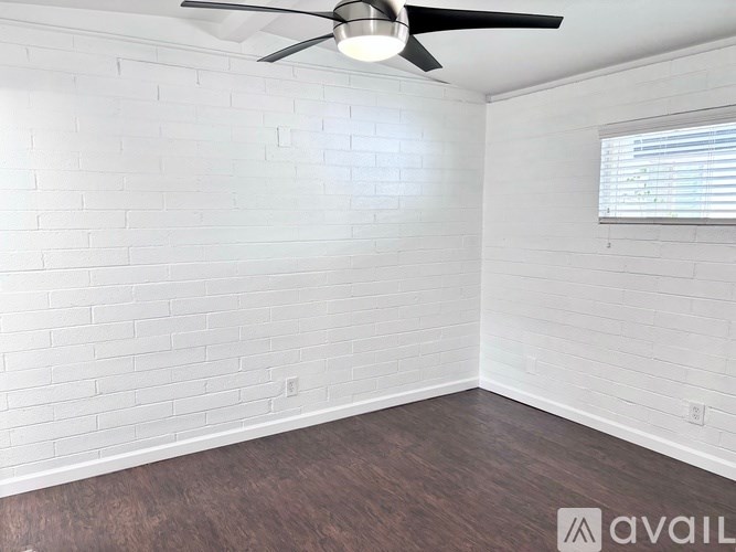 A room with a ceiling fan and a window with blinds.