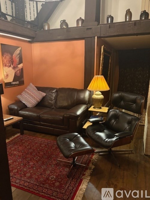 A living room with a brown leather couch and a matching chair.