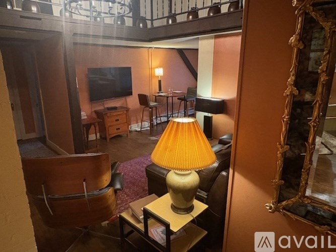 A lamp with a yellow shade is on a table in a room.