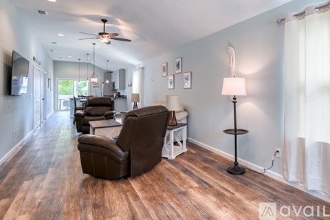 A living room with a brown leather chair and a white side table.