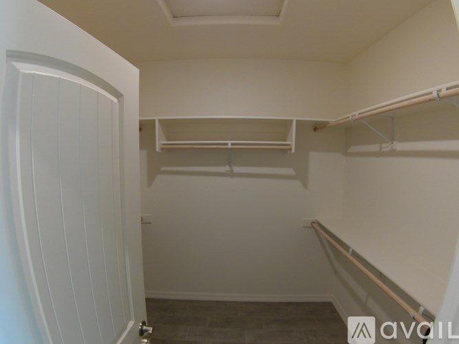 A white closet with shelves and a door.