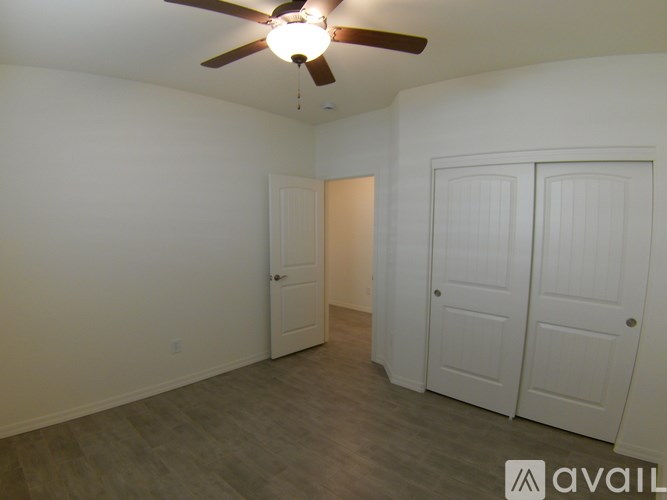 A room with a ceiling fan and two doors.