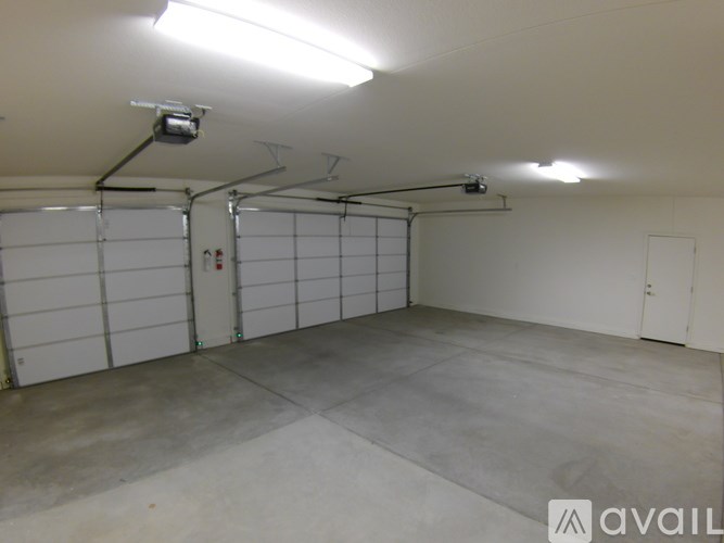 A large, empty garage with a concrete floor and white walls.