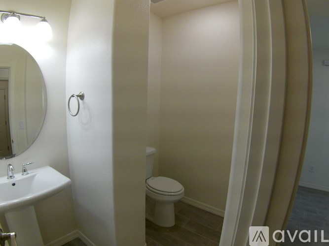 A bathroom with a toilet, sink, and mirror.