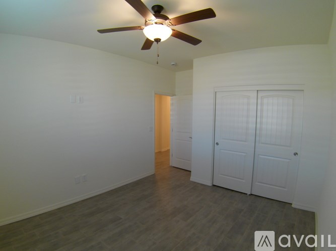 A room with a ceiling fan and two doors.