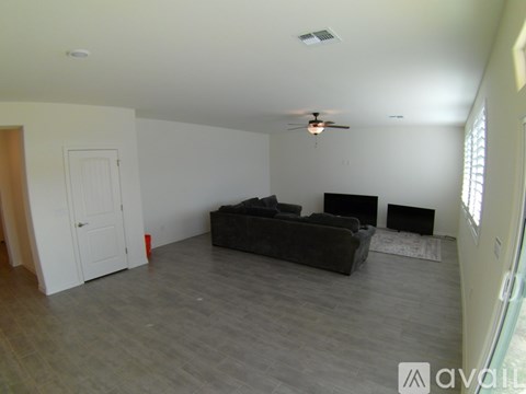 A living room with a black couch and a fireplace.