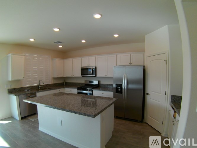 A kitchen with a granite countertop and stainless steel appliances.